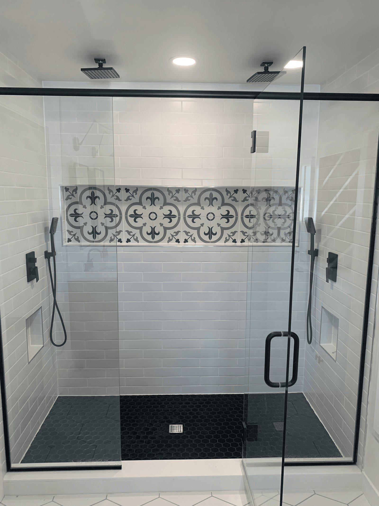 A finished walk-in glass shower with custom subway tile installed by Barr Web Plumbing
